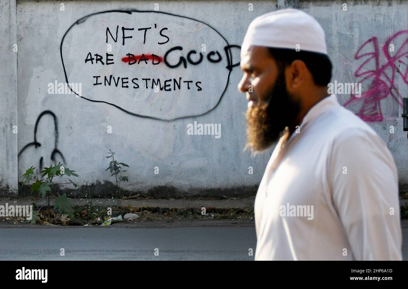 Mumbai, Indien. 18th. Februar 2022. Ein muslimischer Mann geht an einem Graffiti vorbei, das auf einer Wand mit der Aufschrift "NFT's are Good Investments" in Mumbai gemalt ist.Non fungible Tokens (NFT) sind digitale Vermögenswerte, die reale Objekte wie Kunst, Musik, Fotos usw. repräsentieren. (Foto von Ashish Vaishnav/SOPA Images/Sipa USA) Quelle: SIPA USA/Alamy Live News Stockfoto
