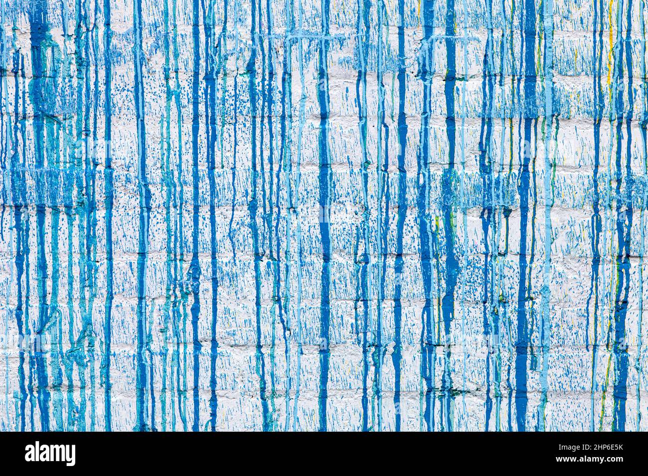 Blaue Farbe tropft auf eine weiße Wand abstrakte Grunge Farbe Hintergrundstruktur Stockfoto