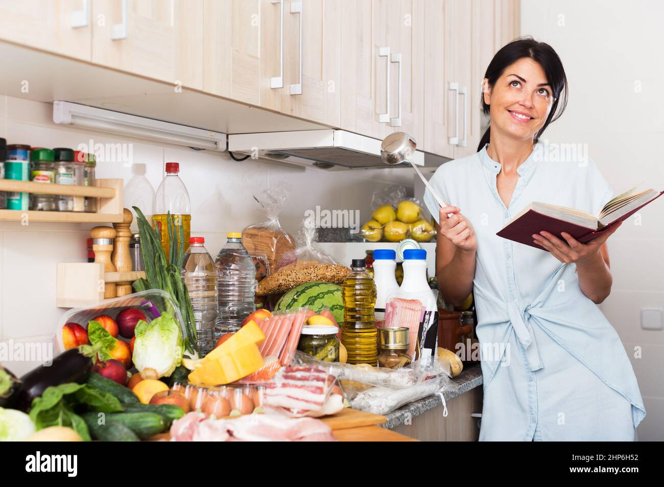 Frau sucht Rezept im Kochbuch Stockfoto