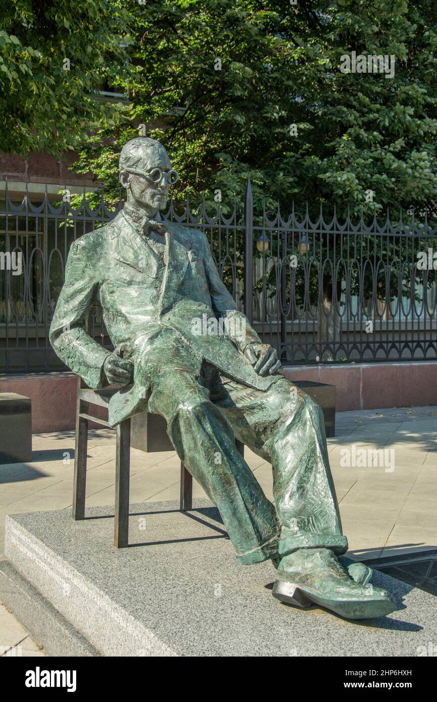 Statue des schweizerisch-französischen Architekten Charles-Edouard Jeannere Le Corbusier vor dem massiven roten Tsentrosojus- oder Centrosojus-Gebäude in Moskau Stockfoto