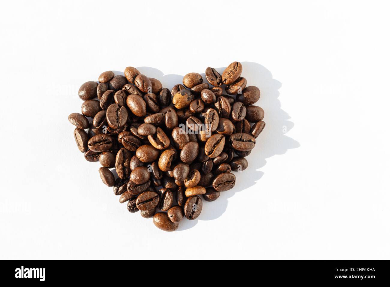 Herzform von Robusta, Arabica-Kaffeebohnen isoliert auf weißem Hintergrund. Ich liebe Kaffee. Kaffeebohnen für Latte, Cappuccino, Mokka, Americano-Kaffee, Stockfoto