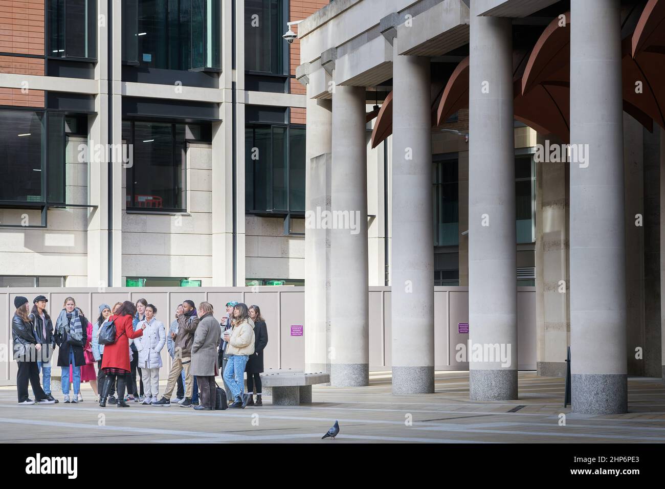 Eine Gruppe von Studenten mit einem Reiseführer an der Börse, Pamernoster Square, Stadt London, England. Stockfoto