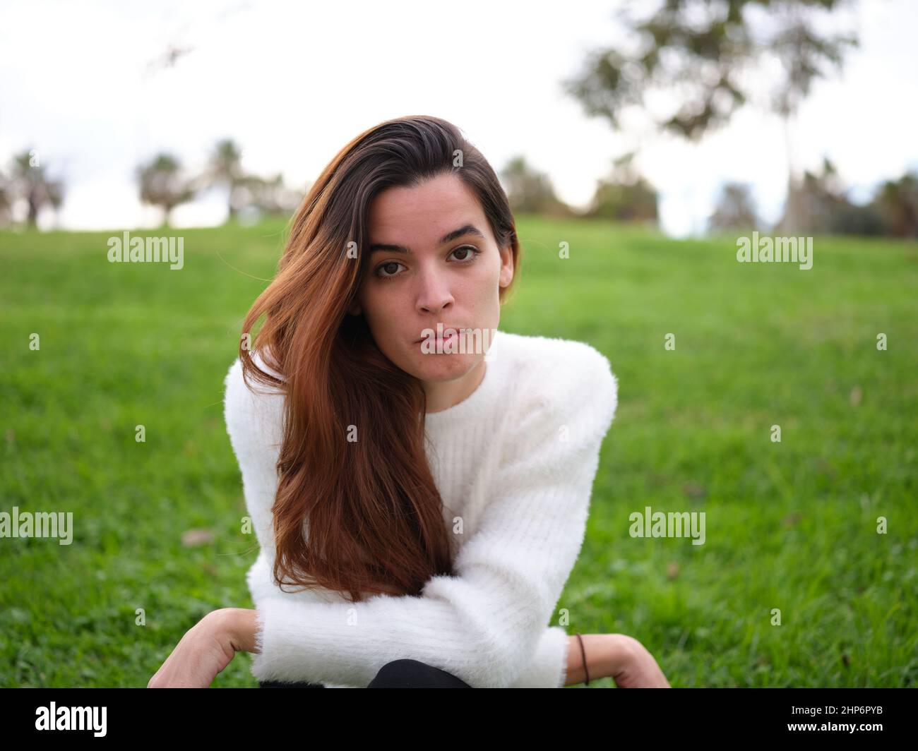 Eine wütende junge Frau im Park, die ernsthaft auf die Kamera schaut Stockfoto