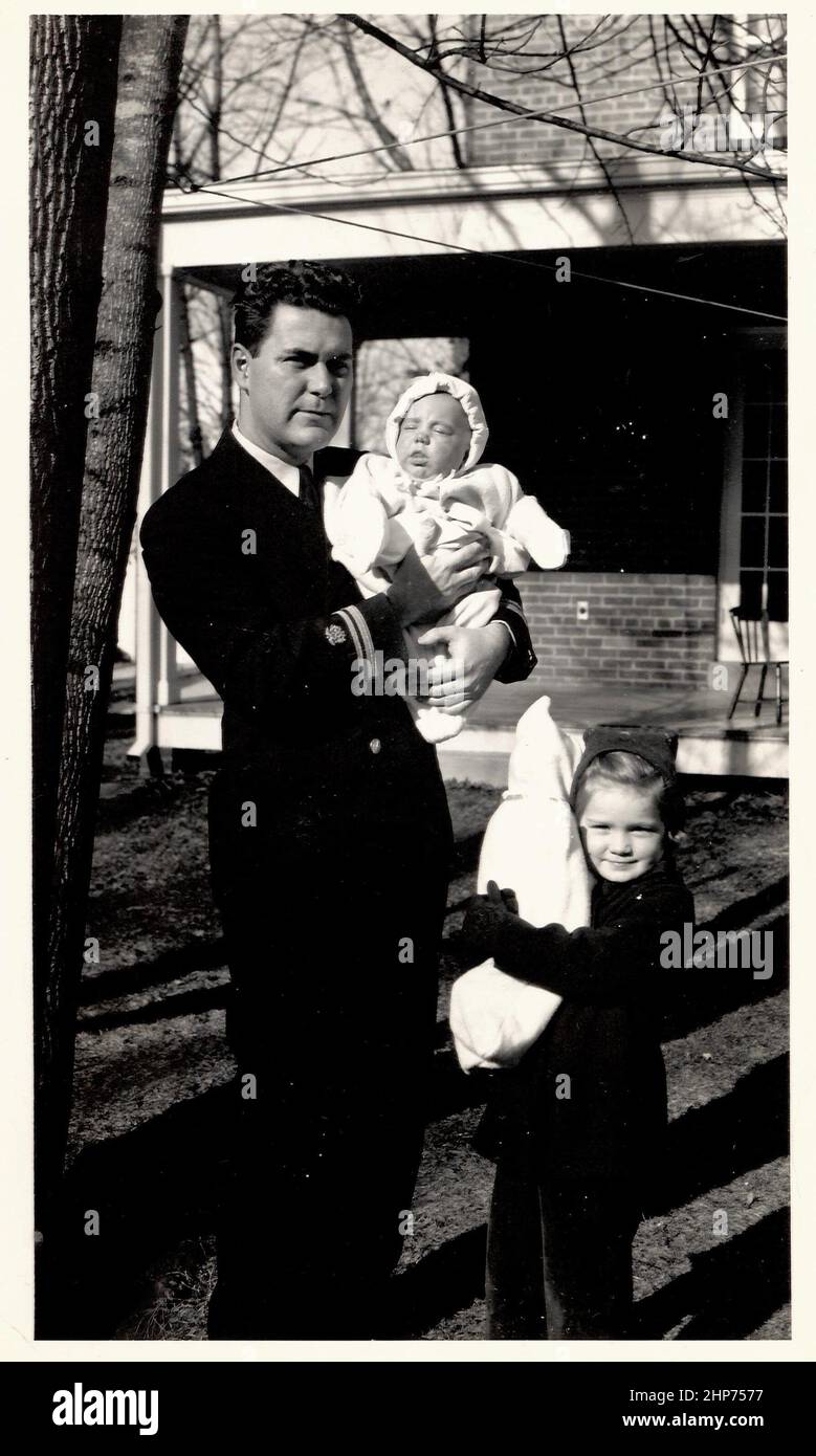 Dr. Richard G. Henderson, in seiner Uniform für den öffentlichen Dienst, hält seinen kleinen Sohn William, während seine Tochter, die Frau, ihre Puppe in der Wiege hält, etwa ein Jahr bevor er an Typhus sterben würde. 1942 Stockfoto