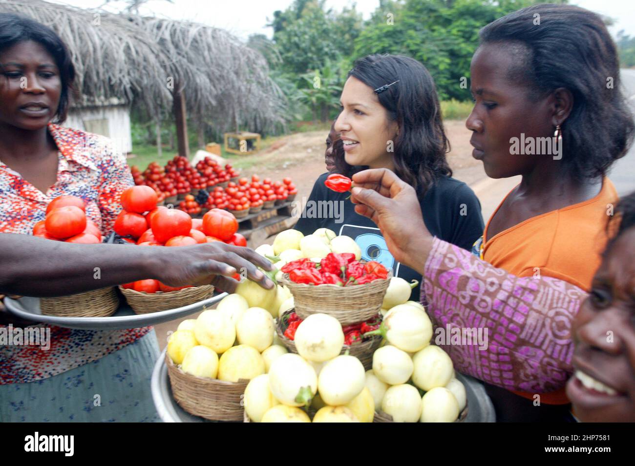 Ghanaische Straßenhändler verkaufen Obst und Gemüse an die berühmte Essensschriftstellerin Vicky Bhogal. Eine Aktivistin von Causes Vickys berühmtes Rezeptbuch für die Make Poverty History Kampagne, „A Fair Feast“ im Jahr 2005, das sie zusammenstellte und herausgab. Das Buch bestand darauf, dass 100% des Erlöses an wohltätige Zwecke gehen, und brachte über £100.000 für die Fairtrade Foundation und Oxfams Make Trade Fair Campaign ein. Bild Gary Roberts/worldwidefeatures.com Stockfoto