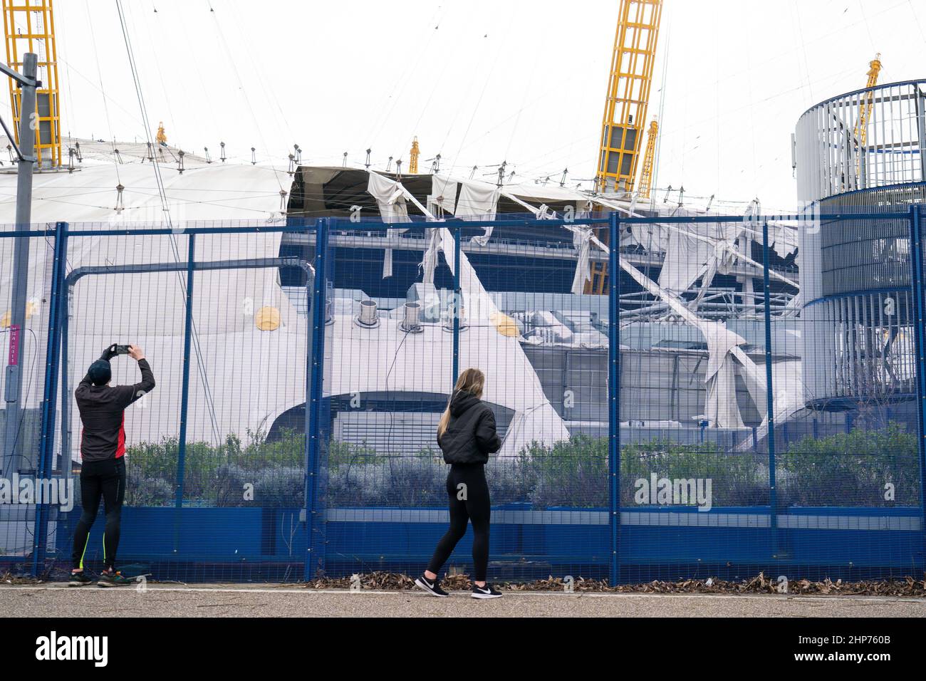 Die Menschen fotografieren die O2 Arena in London, nachdem Teile des Dachs bei starken Winden abgerissen wurden, als der Sturm Eunice anschlug. Eine große Säuberung wird beginnen, nachdem Sturm Eunice Schäden, Störungen und rekordverdächtige Windböen in Großbritannien und Irland verursacht hat, die zum Tod von mindestens vier Menschen führen. Bilddatum: Samstag, 19. Februar 2022. Stockfoto