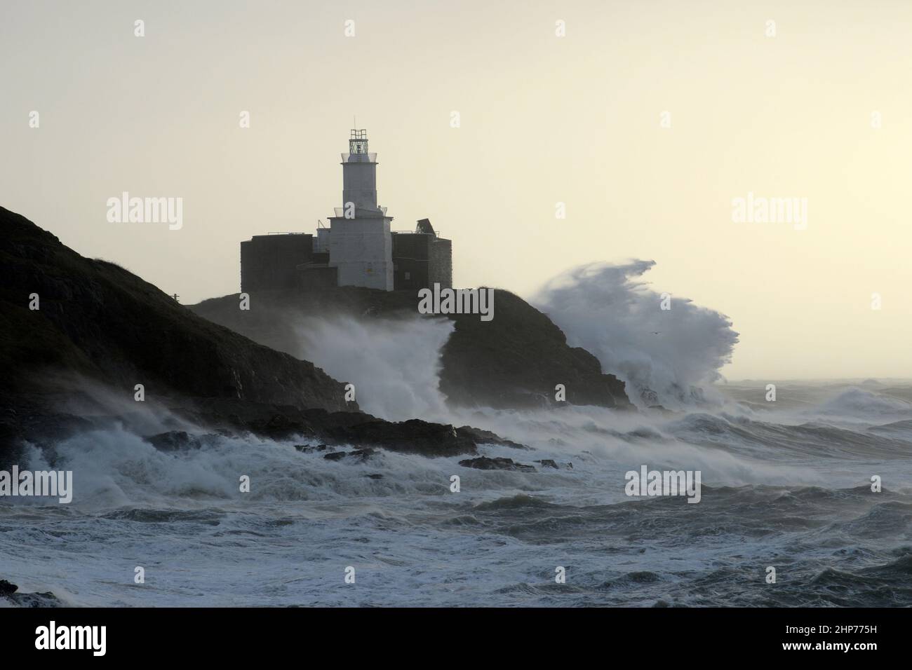 Sturm Eunice an den Mumbles. Swansea, Wales, Großbritannien. Riesige Wellen krachen über Leuchtturm und Landzunge, 90mph Winde wehen in den Wind. Stockfoto