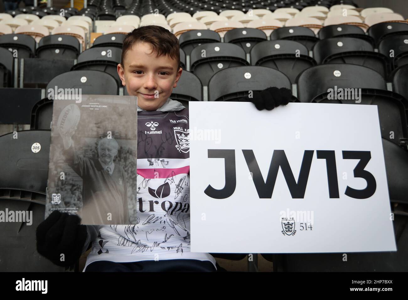 Ein junger Hull FC-Fan hält eine Sonderausgabe des 18th-Mann-Spieltags-Programms, das Johnny Whiteley MBE gewidmet ist, zusammen mit einem JW13-Zeichen vor dem Spiel bereit Stockfoto