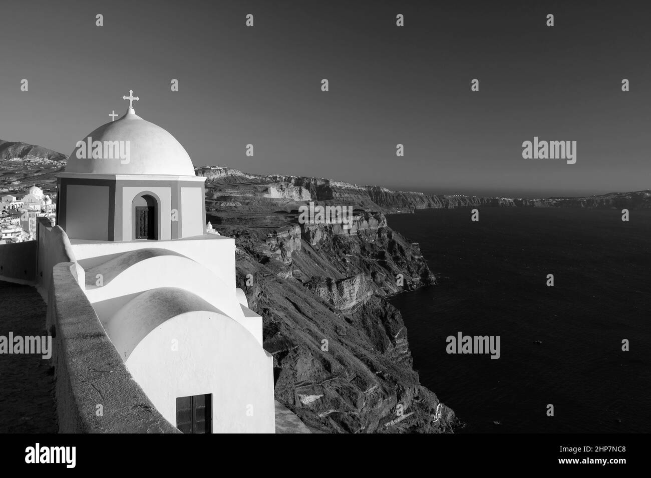Blick auf eine wunderschöne orthodoxe Kirche, den blauen Himmel und die Ägäis in Santorini Griechenland in Schwarz und Weiß Stockfoto