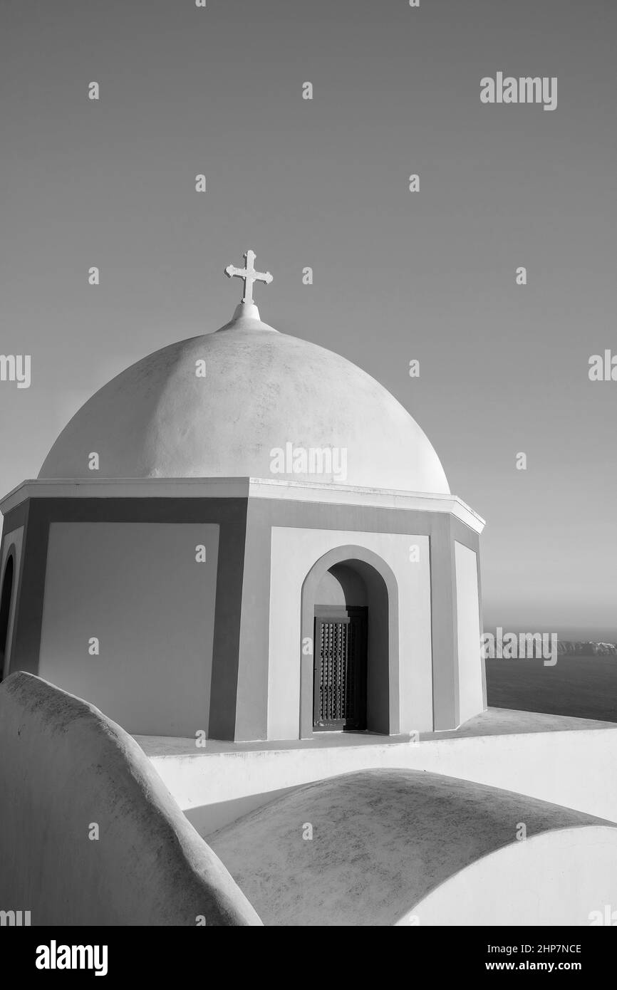 Blick auf eine wunderschöne orthodoxe Kirche, den blauen Himmel und die Ägäis in Santorini Griechenland in Schwarz und Weiß Stockfoto