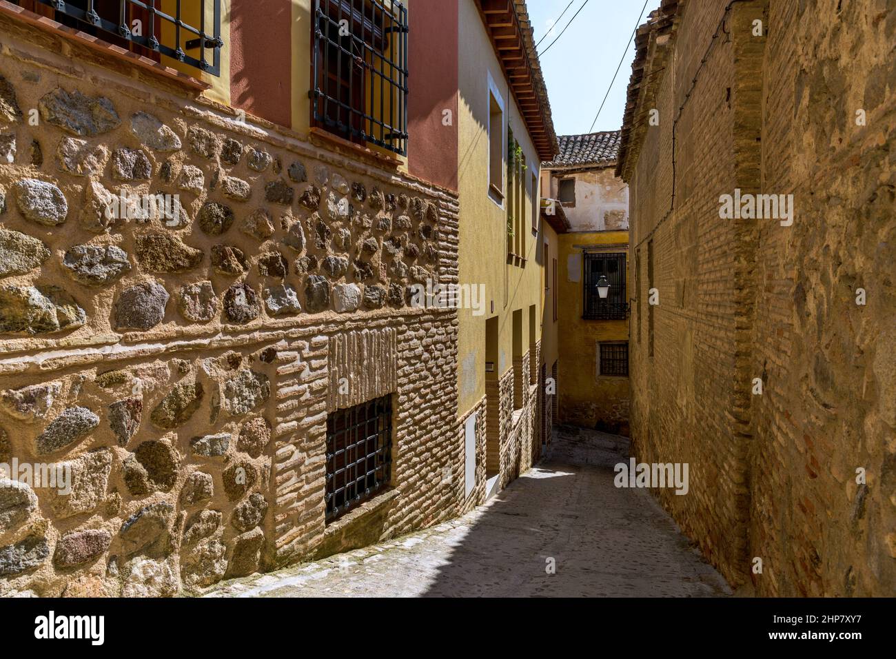 Old Town Alley - Ein Weitwinkelblick auf eine schmale und steile Gasse in der historischen Stadt Toledo an einem sonnigen Herbstnachmittag. Toledo, Spanien. Stockfoto