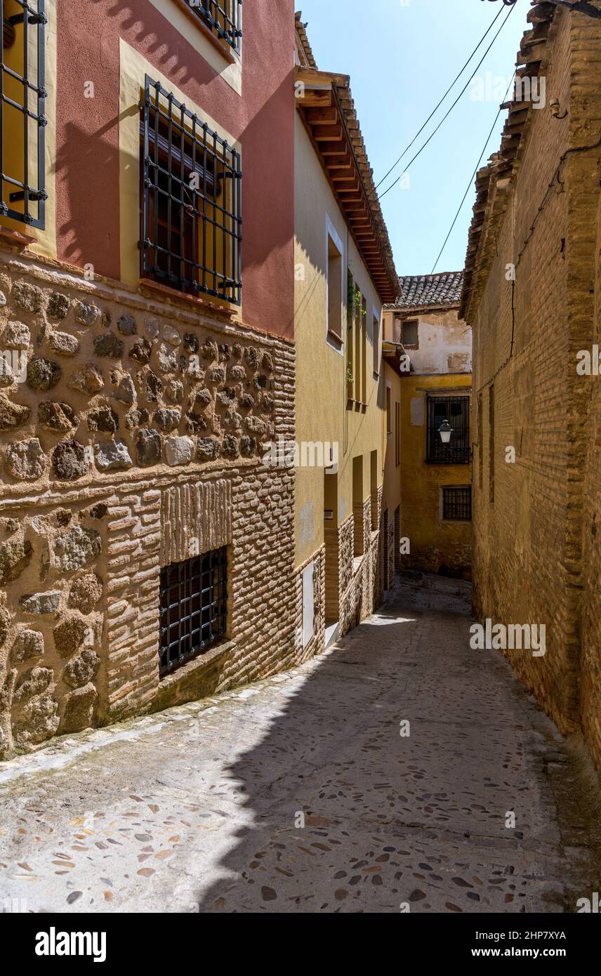 Old Town Alley - Eine vertikale Weitwinkelansicht einer engen und steilen Gasse in der historischen Stadt Toledo an einem sonnigen Herbstnachmittag. Toledo, Spanien. Stockfoto