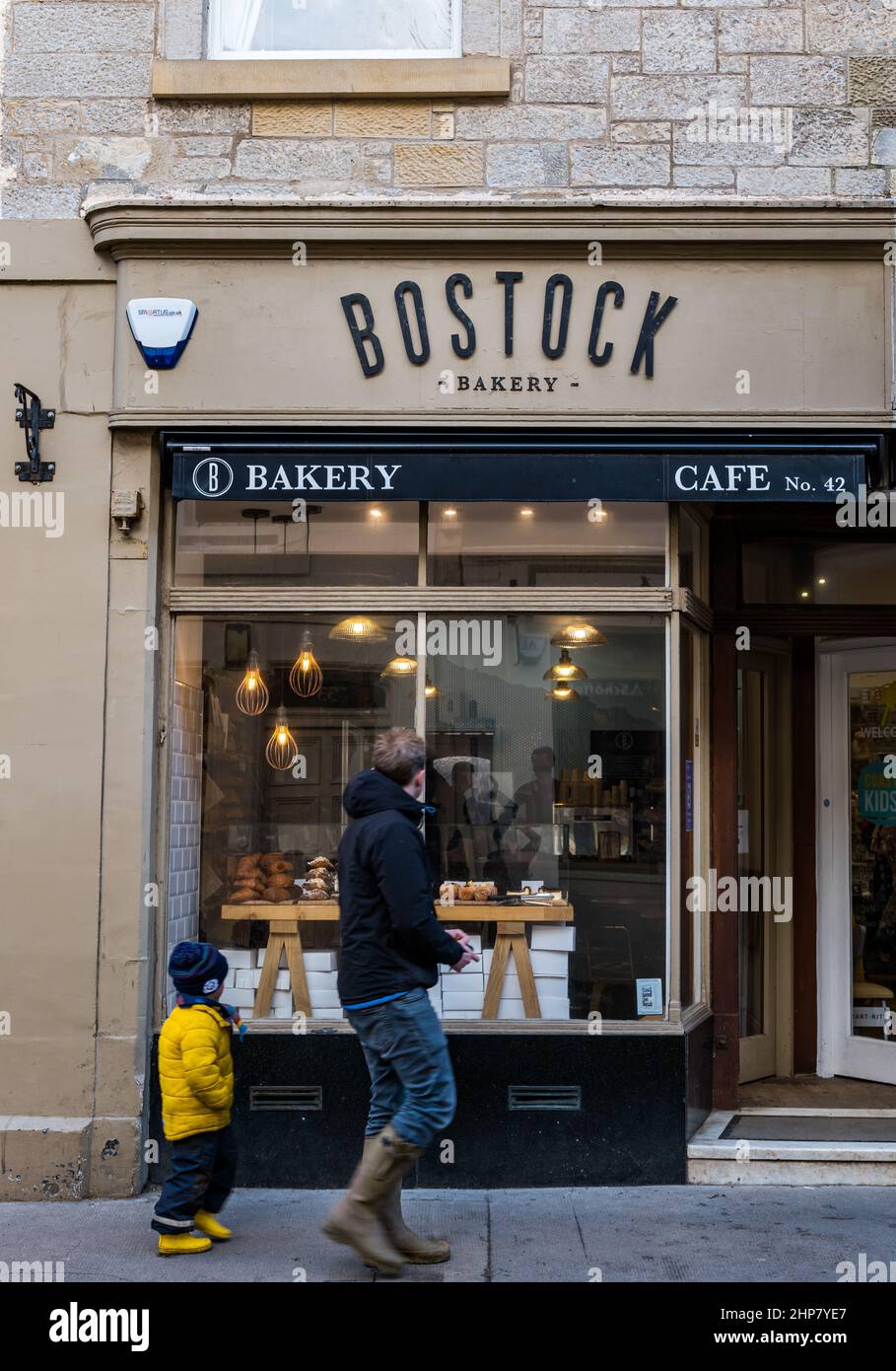 Vor dem Bostock Bakery-Shop laufen Mann und Kind vorbei und schauen sich Gebäck an, High Street, North Berwick, Schottland, Großbritannien Stockfoto