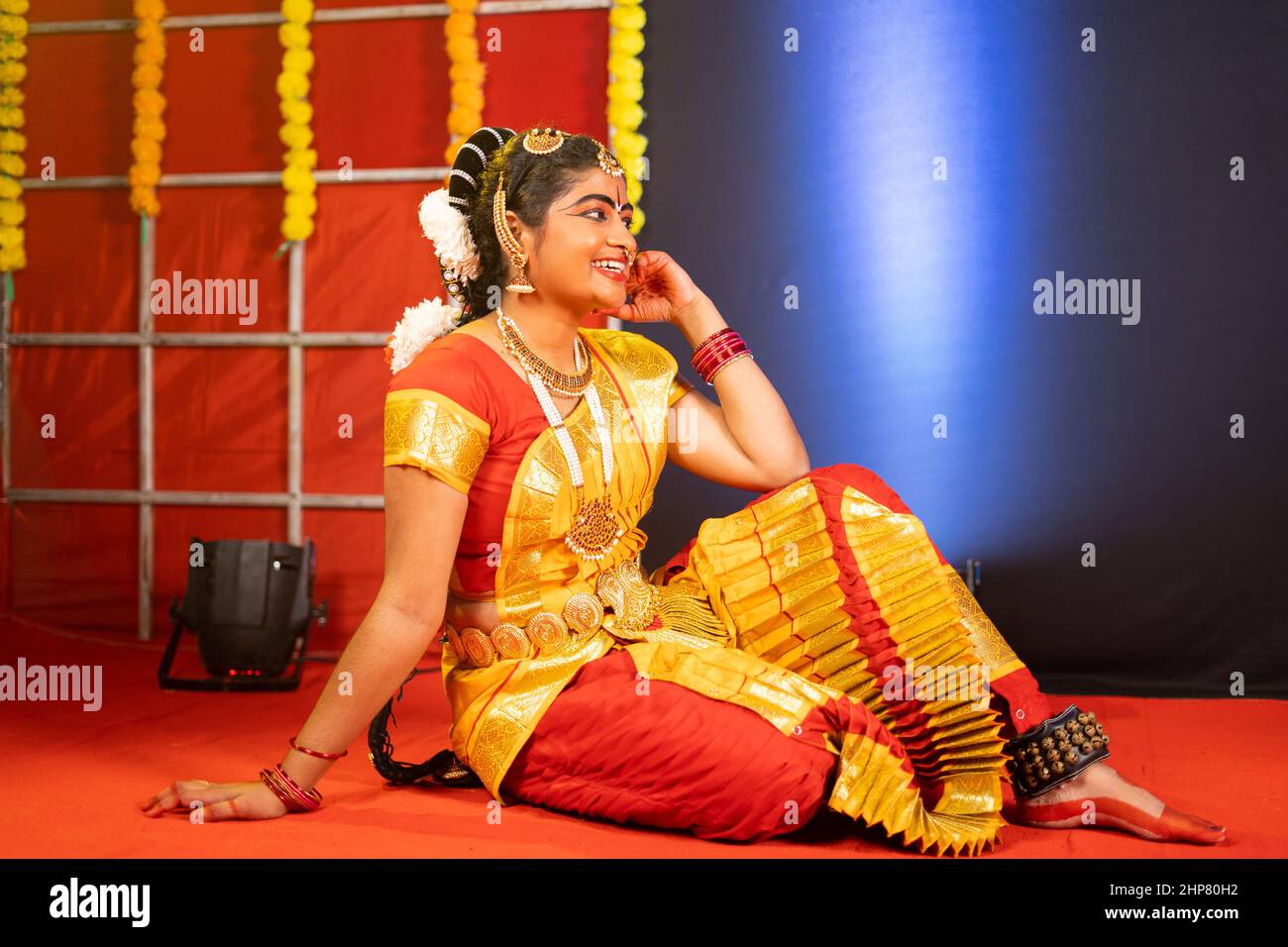 Junge Bharatnatyam-Tänzerin, die nach dem Tanzen auf der Bühne lacht - Konzept der Pause, Entspannung und professioneller Tänzer. Stockfoto