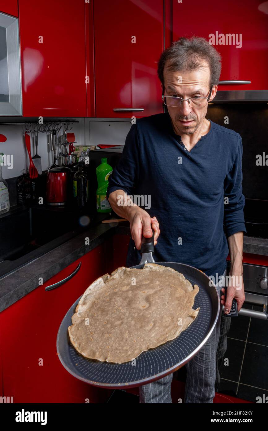 Zubereitung bretonischer Pfannkuchen. Ein Mann dreht Pfannkuchen Stockfoto