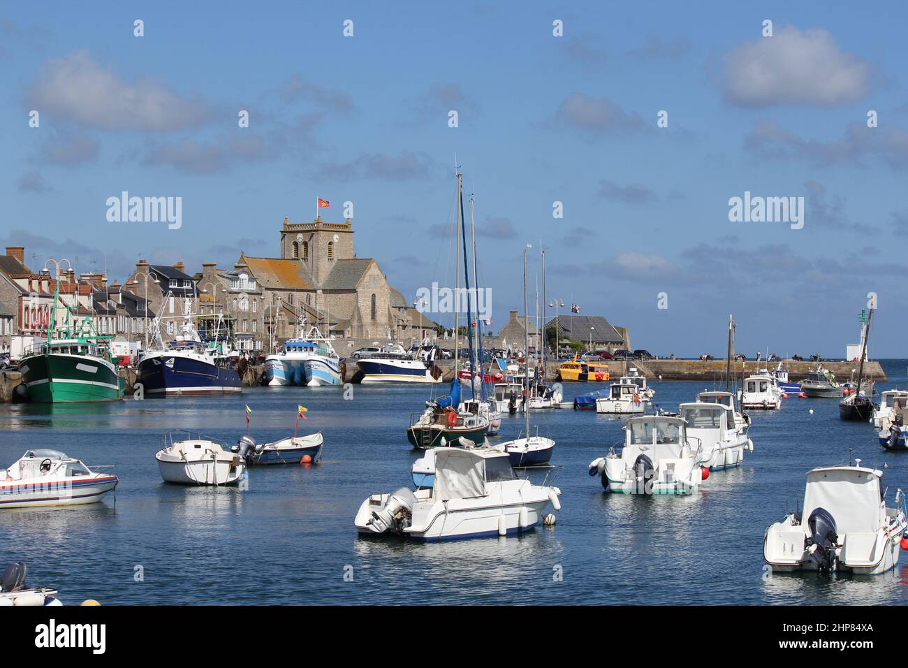 Wunderschöne französische Küstenlandschaft des Hafens in barfleur in der normandie mit Fischerbooten vor der Skyline mit historischen Gebäuden Stockfoto