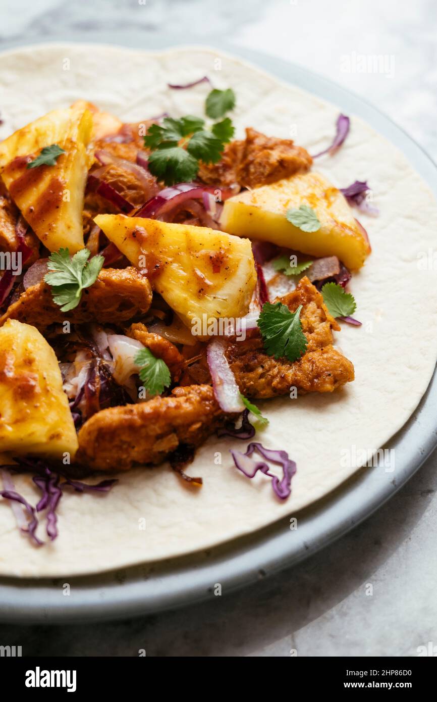 Burritos mit würzigen TVP-Locken, Kohlraw und frischer Ananas Stockfoto