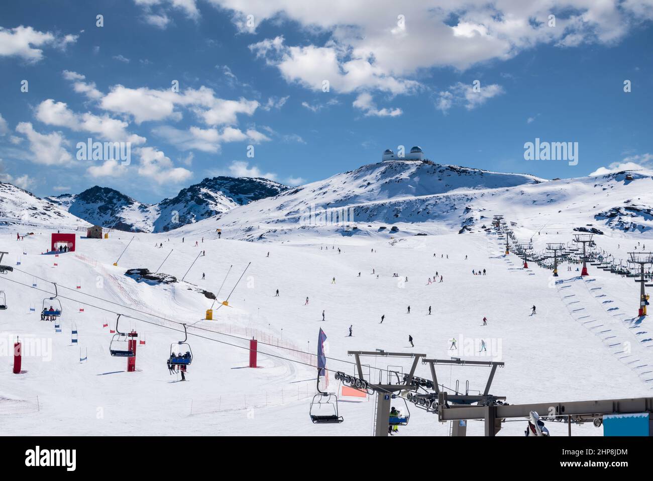 Gesamtansicht der Sierra Nevada, Granada, Andalusien, Spanien mit der Sternwarte im Hintergrund an einem sonnigen Tag mit Wolken Stockfoto