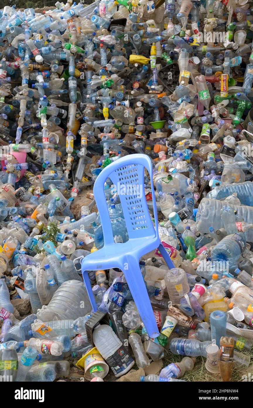 KENIA, Nairobi, Kibera Slum, Plastikflaschen von Nestle, Pepsico, Coca Cola and Co., Dumping, Getränkehersteller ersetzen Mehrwegglasflaschen mehr und mehr durch Einwegglasflaschen, aufgrund fehlender Recyclingsysteme wachsen und wachsen die Abfallberge, in der Mitte ein Plastikstuhl Monobloc / KENIA, Nairobi, Kibera Slum, Plastikflaschen von Coca Cola und Co, Coca Cola reduziert in Afrika die Glaspfandflaschen zunehmend und steigt dafür mehr auf den Verkauf von Einwegflaschen aus Plastik um, die Müllberge wachsen, Recycling Systeme fehlen, dazwischen ein Plastikstuhl Monobloc Stockfoto