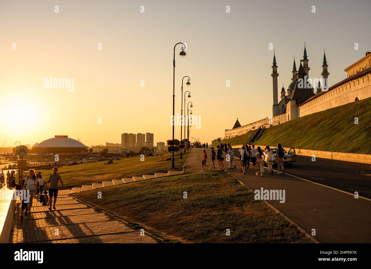 Kasan, Russland - 19. Juni 2021: Menschen gehen bei Sonnenuntergang in der Nähe des Kasanischen Kremls, Tatarstan. Dieser Ort ist Touristenattraktion von Kazan. Sonniger Blick auf die Altstadt. Stockfoto