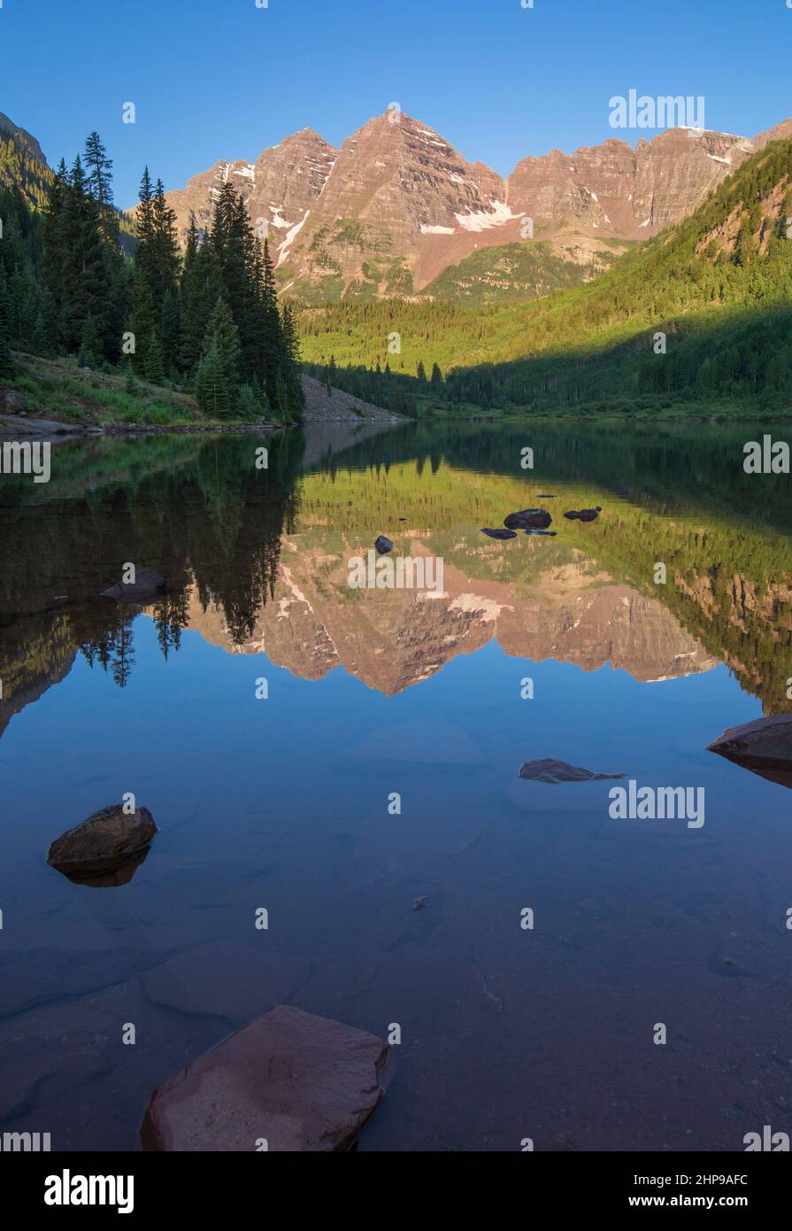 Maroon Bells, kristallklarer Maroon Lake und wunderschöne Sommerreflexionen am frühen Morgen in der Nähe von Aspen, Colorado Stockfoto