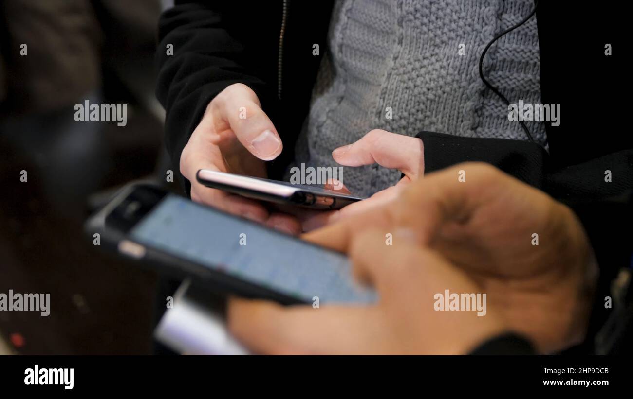 Nahaufnahme von Smartphones in den Händen von zwei jungen Männern. Neue Generation in einem Café aus nächster Nähe. Kommunikationskonzept. Paar mit digitalen Gadgets für onli Stockfoto