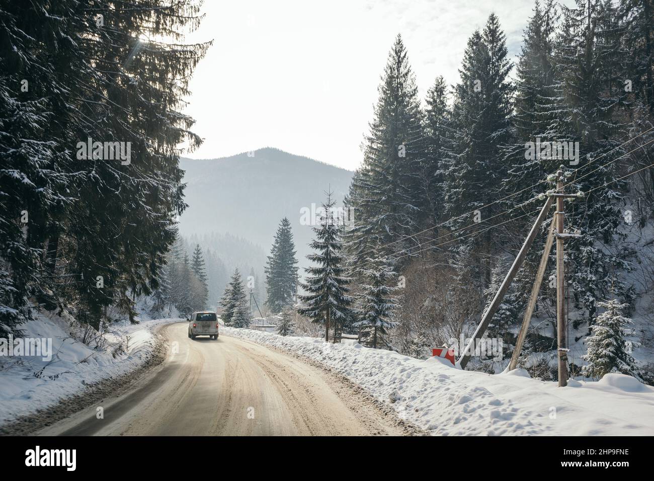 Ein Pfad mit Bäumen auf der Seite eines schneebedeckten Hanges Stockfoto