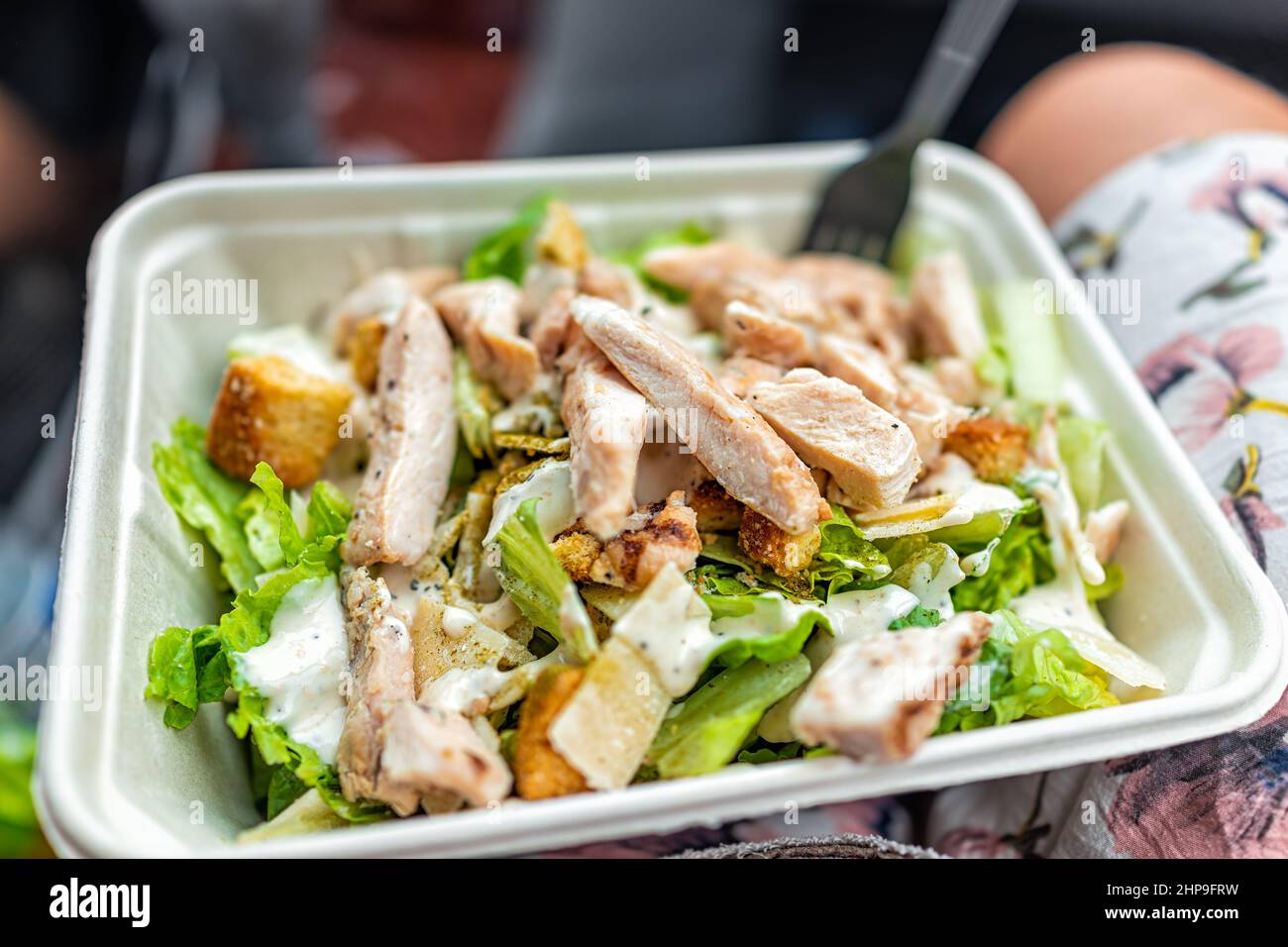 Nahaufnahme von frischem cremigem caesar Dressing Salat mit gehacktem Gemüse Romaine Salatgemüse und gegrillten Hühnern Streifen in Tablettkarton so schnell Stockfoto