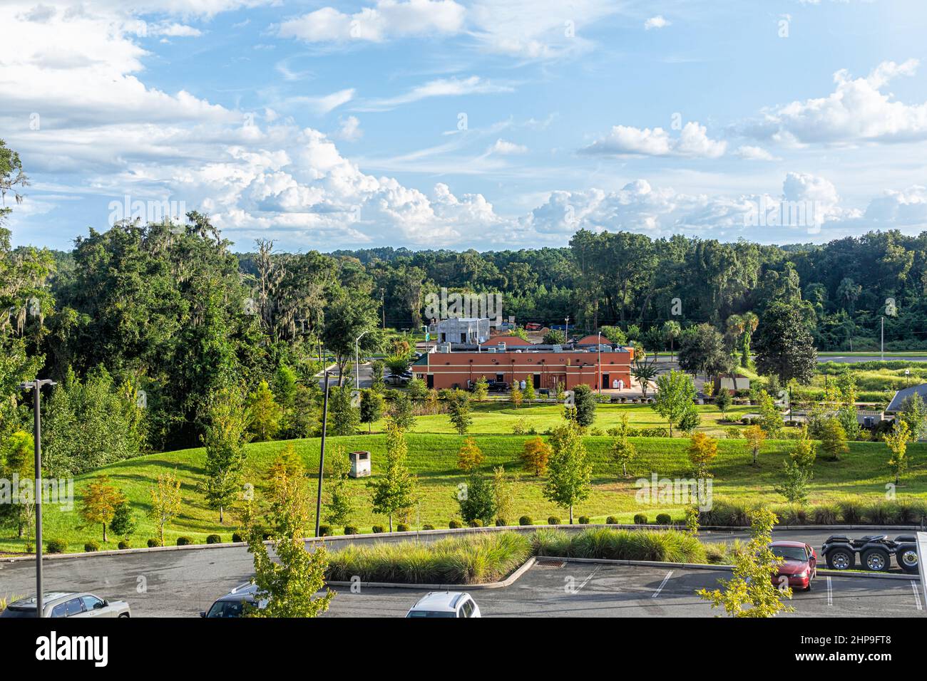 Hochwinkel-Ansicht der Sommerlandschaft in Alachua, Florida in der Nähe von Gainesville mit Bauwagen Parkplatz und grünen Bäumen mit blauem Himmel Stockfoto