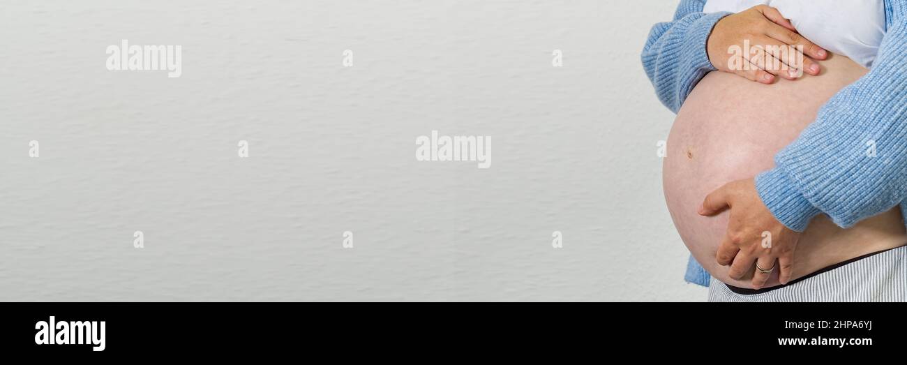 Schwangere sitzt zu Hause auf dem Bett Schwangerschaft, Mutterschaft, Vorbereitung und Erwartung Konzept. Stockfoto