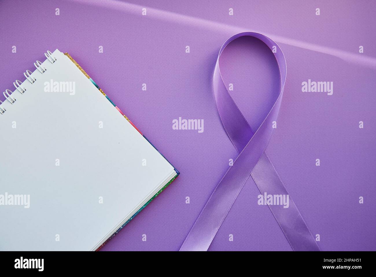 Notizblock und violettes Band zum Purple Day - Welt-Epilepsietag, März 26. Symbol des Epilepsietages. Stockfoto