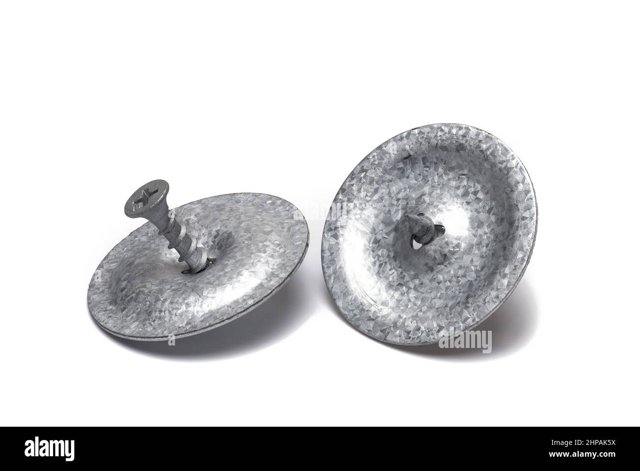 Nahaufnahme von zwei silberverzinkten Metallplatten mit Holzschrauben zur Befestigung von Bitumenfolien auf Dächern und auf Holzuntergründen auf weißem Hintergrund zu sehen Stockfoto