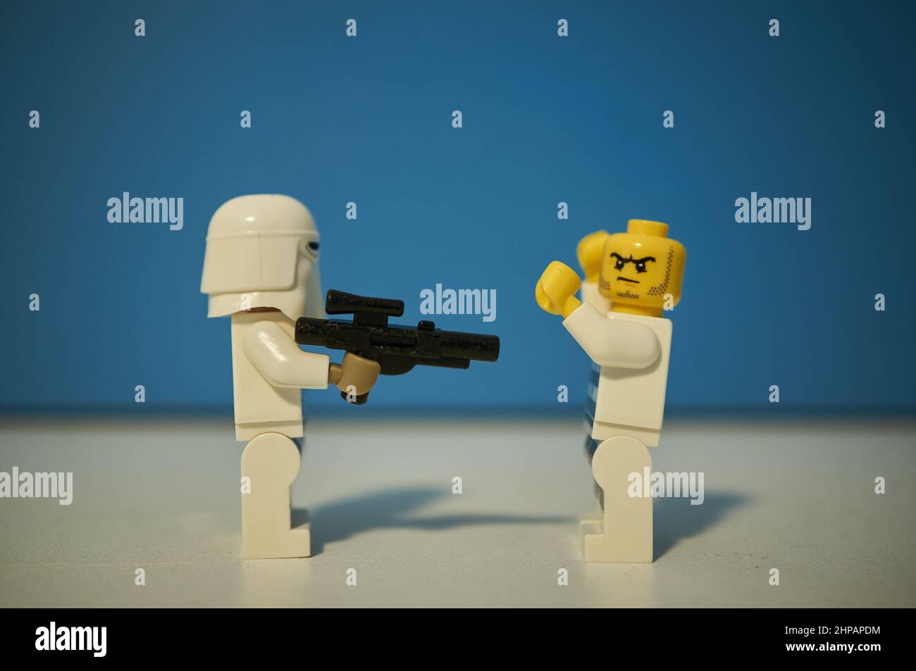 LEGO Star Wars Schneetrooper Figur schießen einen Schurken auf einem blauen Hintergrund. Stockfoto