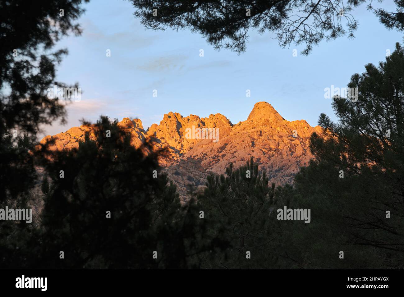 El Yelmo, der Gipfel von La Pedriza vom Wald aus gesehen bei Sonnenuntergang. Stockfoto