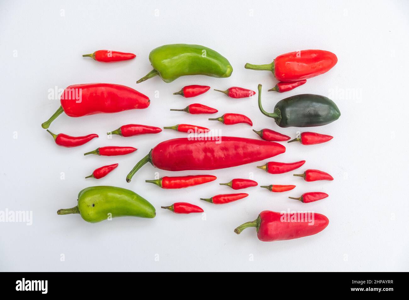 Rote und grüne Chilis auf weißem Hintergrund. Chilischoten sind auch als chile, chilischote, Chilischote oder Chili bekannt. Capsicum. Stockfoto