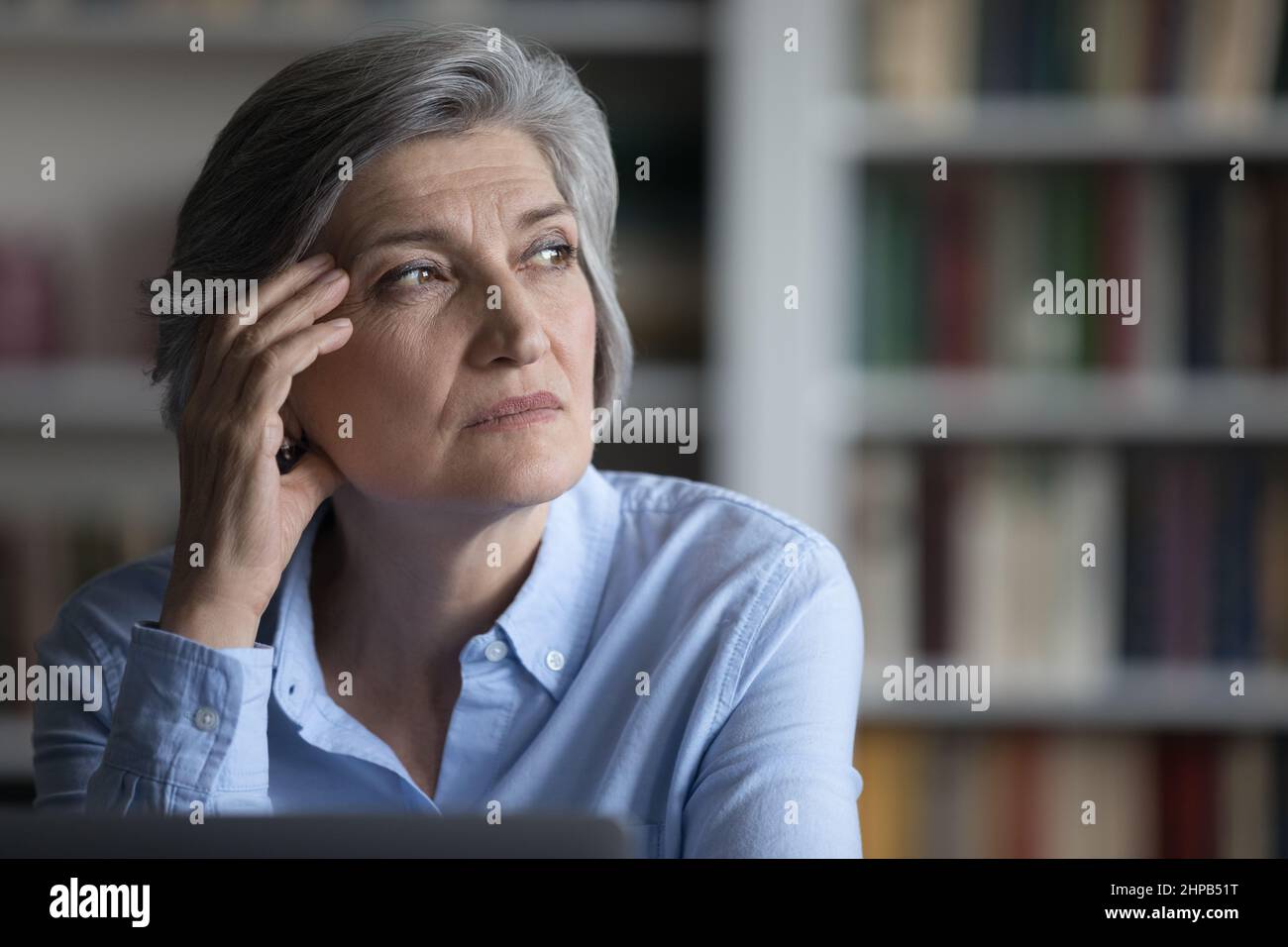 Abgelenkt von Computerarbeit gestresste alte Frau, die in der Ferne schaute. Stockfoto