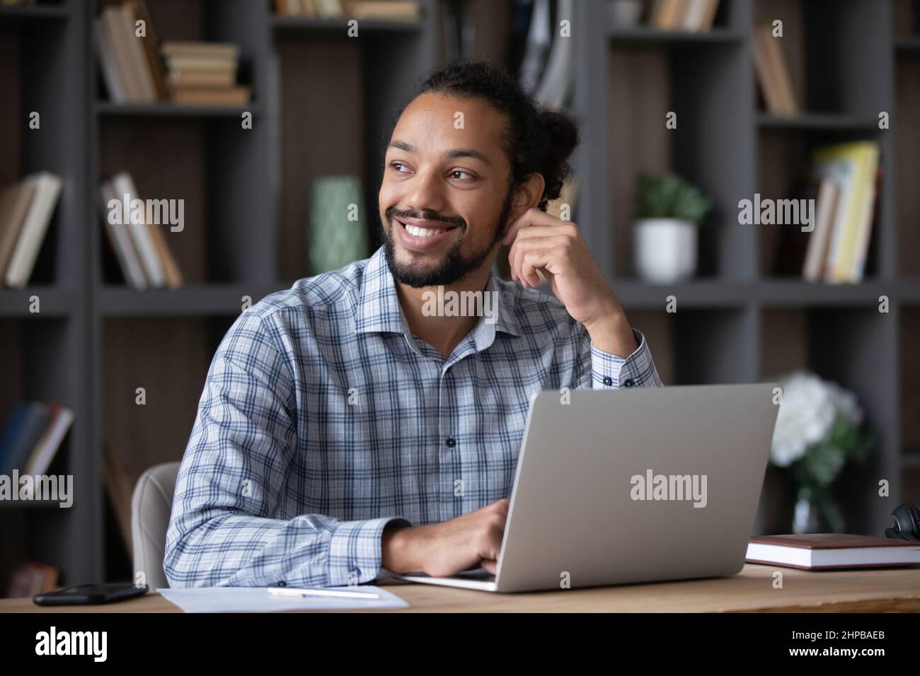 Abgelenkt von Laptop-Arbeit lächelnden afrikanischen Mann in der Ferne zu sehen. Stockfoto