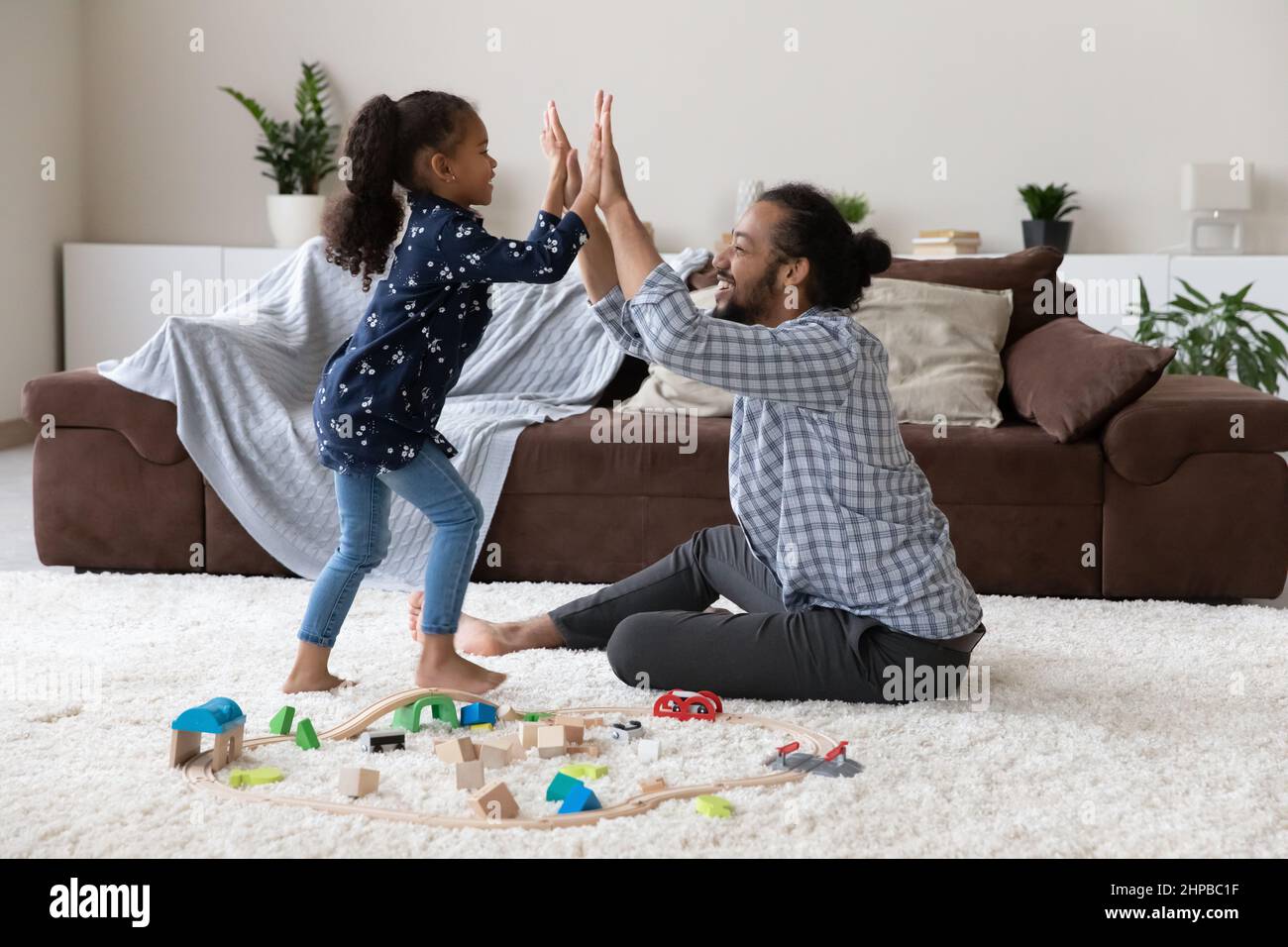 Fröhliche afroamerikanische Familie aus zwei Generationen, die Spielzeug spielt. Stockfoto