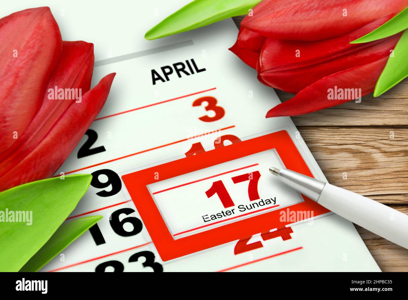 Kalender Ostersonntag 2022. April 17 mit roten Tulpen auf Holzhintergrund Stockfoto