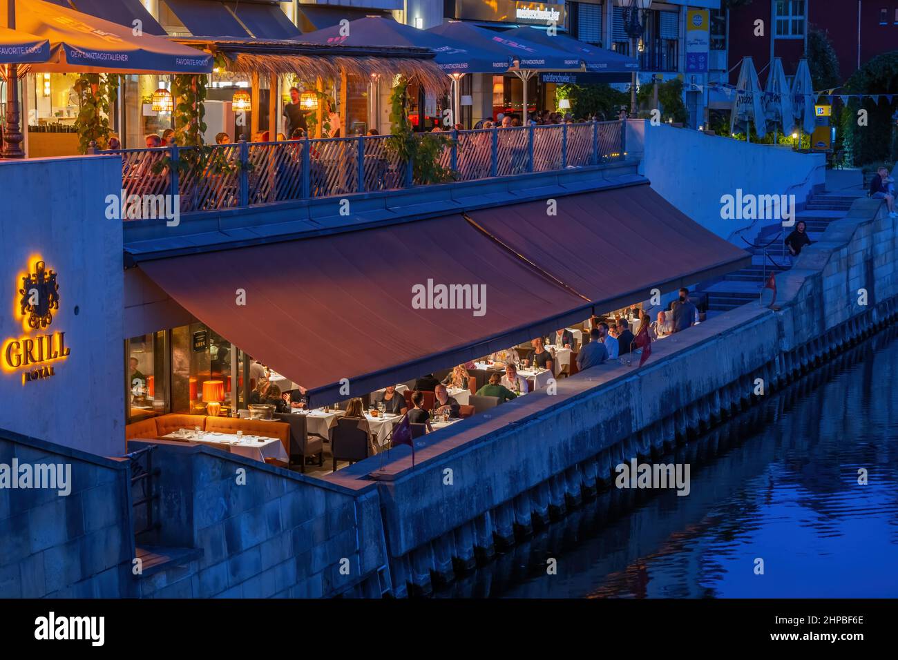 Berlin, Deutschland, Restauranttische der Bar Grill Royal und Meisterschueler in der Friedrichstraße bei Nacht am Ufer der Spree im Zentrum von Mitte Stockfoto