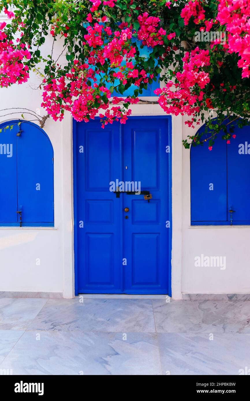 Alte blaue Tür und rosa Blumen, traditionelle griechische Architektur, Santorini Insel, Griechenland. Stockfoto