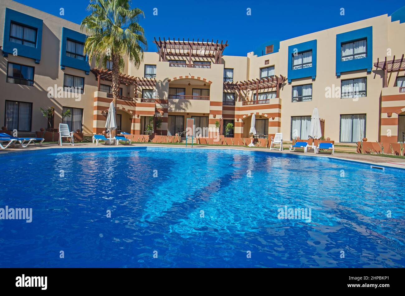 Swimmingpool mit Gebäuden in einem luxuriösen tropischen Hotelresort vor blauem Himmel Stockfoto