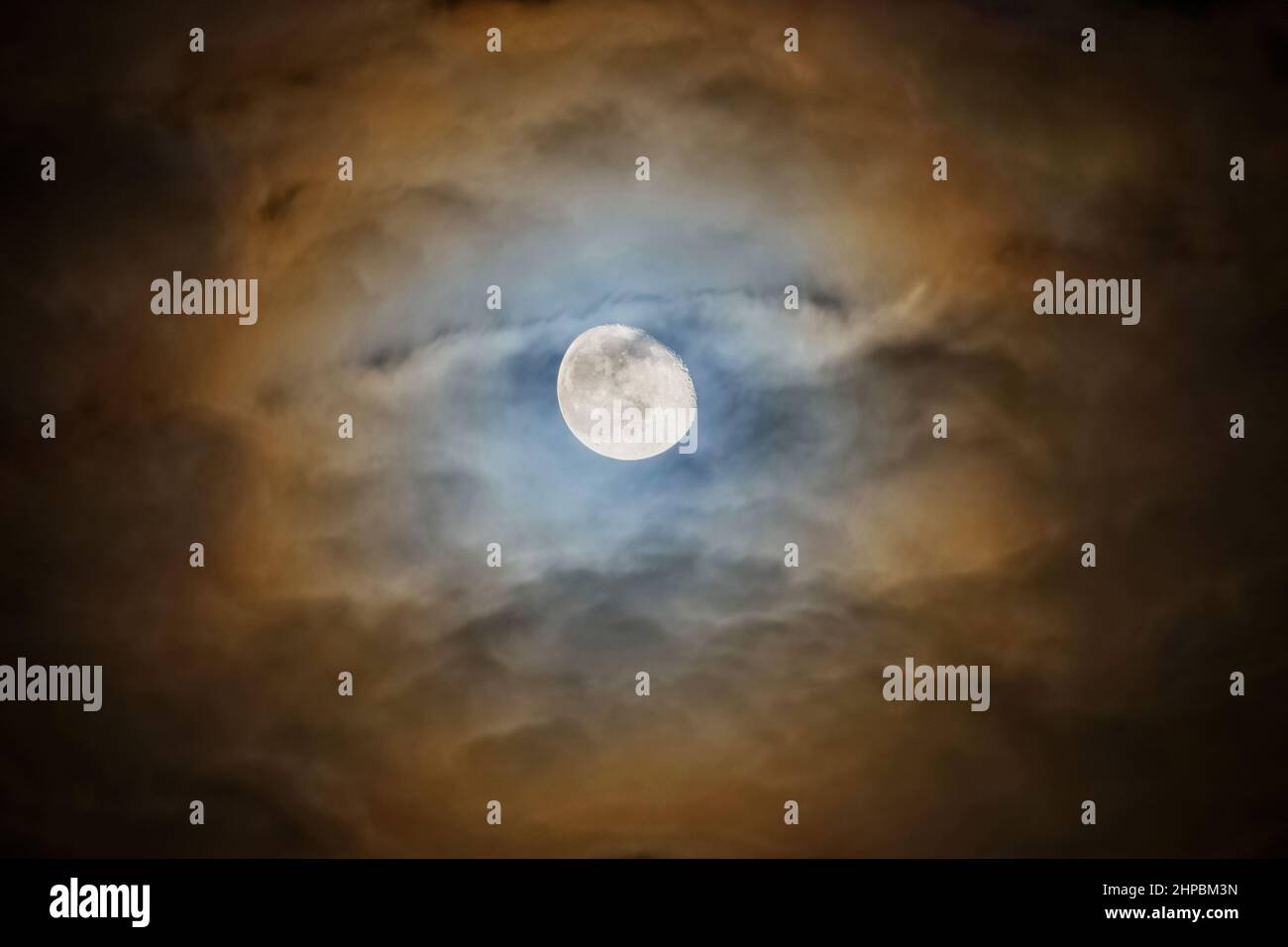 Mystery gruseliger Mond, der durch Wolken scheint, leuchtender, farbenfroher Mondschein Stockfoto