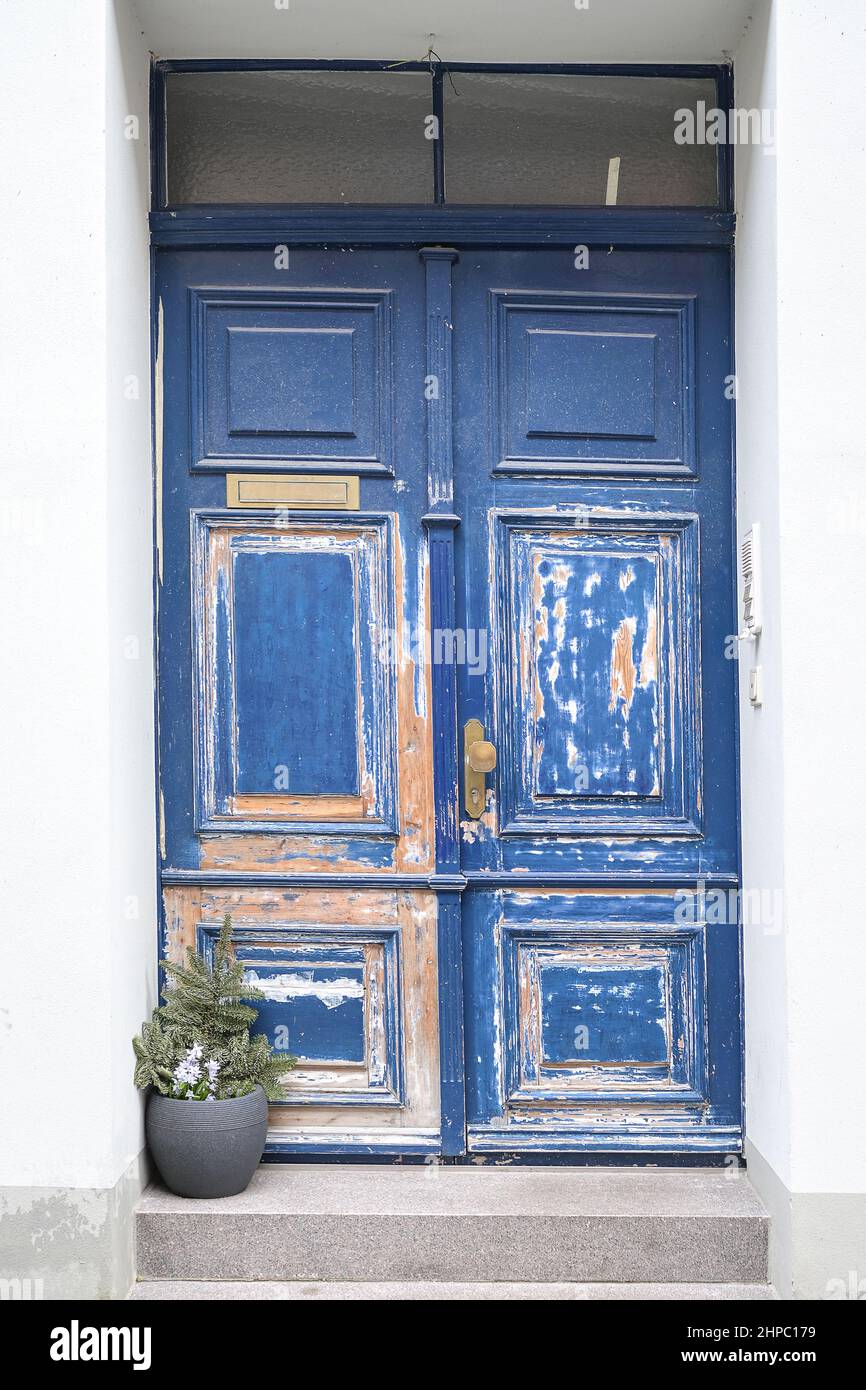 Blaue, renovierungsbedürftige Holztür mit teilweise geschliffener Farbe im Eingang eines historischen Altstadthauses in Lübeck Stockfoto