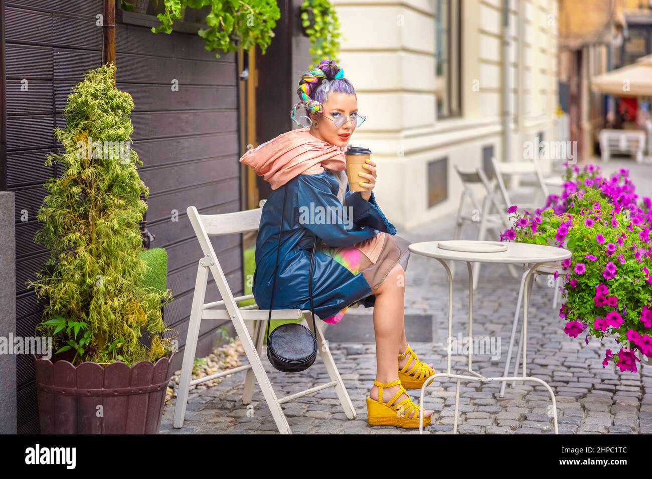 Cool gen z Mädchen mit Piercing und verrückte Haare genießen Sie Kaffee zum Mitnehmen auf der Straße Café Stockfoto