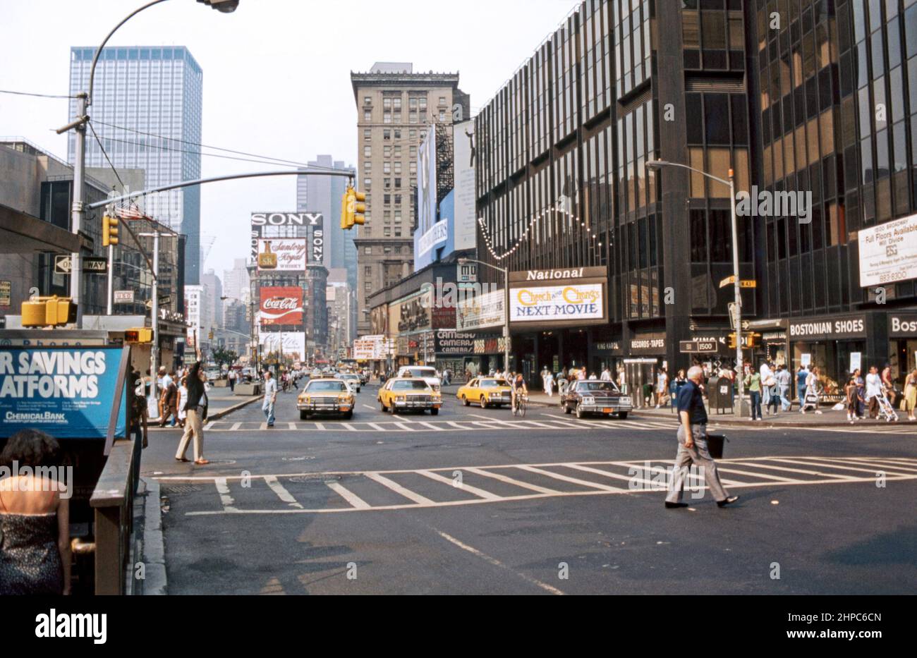 Times Square im Jahr 1980, Blick nach Norden entlang der 7. Avenue am Broadway/West 44. Street, New York City, USA. Ein Display zeigt an, dass die neueste Filmveröffentlichung ‘Cheech and Chong’s Next Movie’ ist. Der Times Square ist ein wichtiger kommerzieller Knotenpunkt, Touristenort und Unterhaltungsviertel im Stadtteil Midtown Manhattan von New York, an der Kreuzung von Broadway und Seventh Avenue. Hell erleuchtet von zahlreichen Werbetafeln und Werbeplakaten erstreckt er sich von den Straßen West 42. bis West 47. und wird manchmal als ‘The Crossroads of the World’ bezeichnet – ein altes Foto aus dem Jahr 1980s. Stockfoto