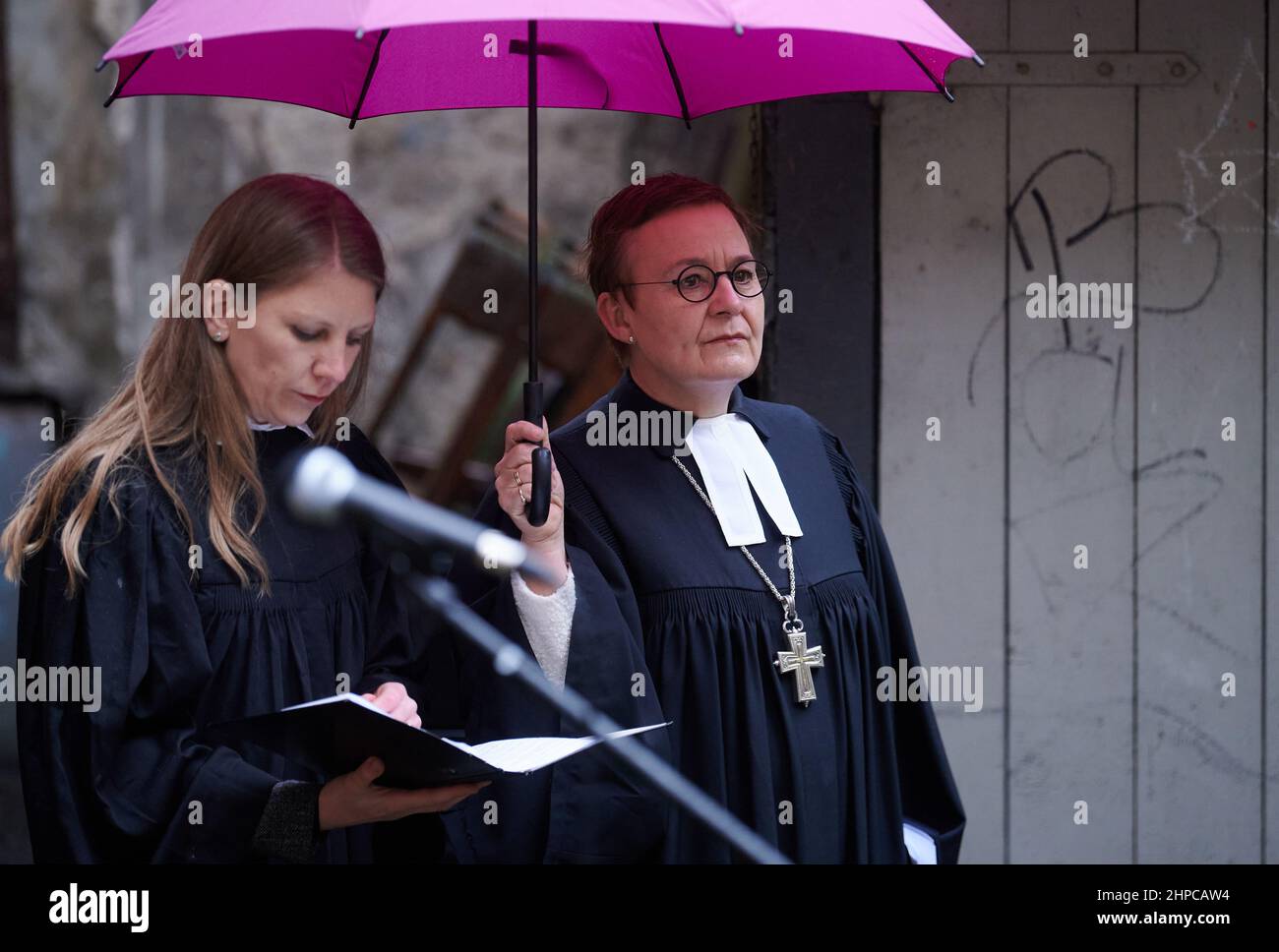 Berlin, Deutschland. 20th. Februar 2022. Almut Bellmann (l.), Pfarrer, und Ulrike Trautwein, Pfarrerin und Generalsuperintendentin des Berliner Bezirks der Evangelischen Kirche, halten im Innenhof der Paul-Gerhardt-Kirche einen Gedenkgottesdienst ab. Ein unbekannter Täter hatte die Kirche am 20. Januar 2022 in Brand gesetzt. Der Altar und die Orgelpfeifen wurden zerstört. Quelle: Annette Riedl/dpa/Alamy Live News Stockfoto