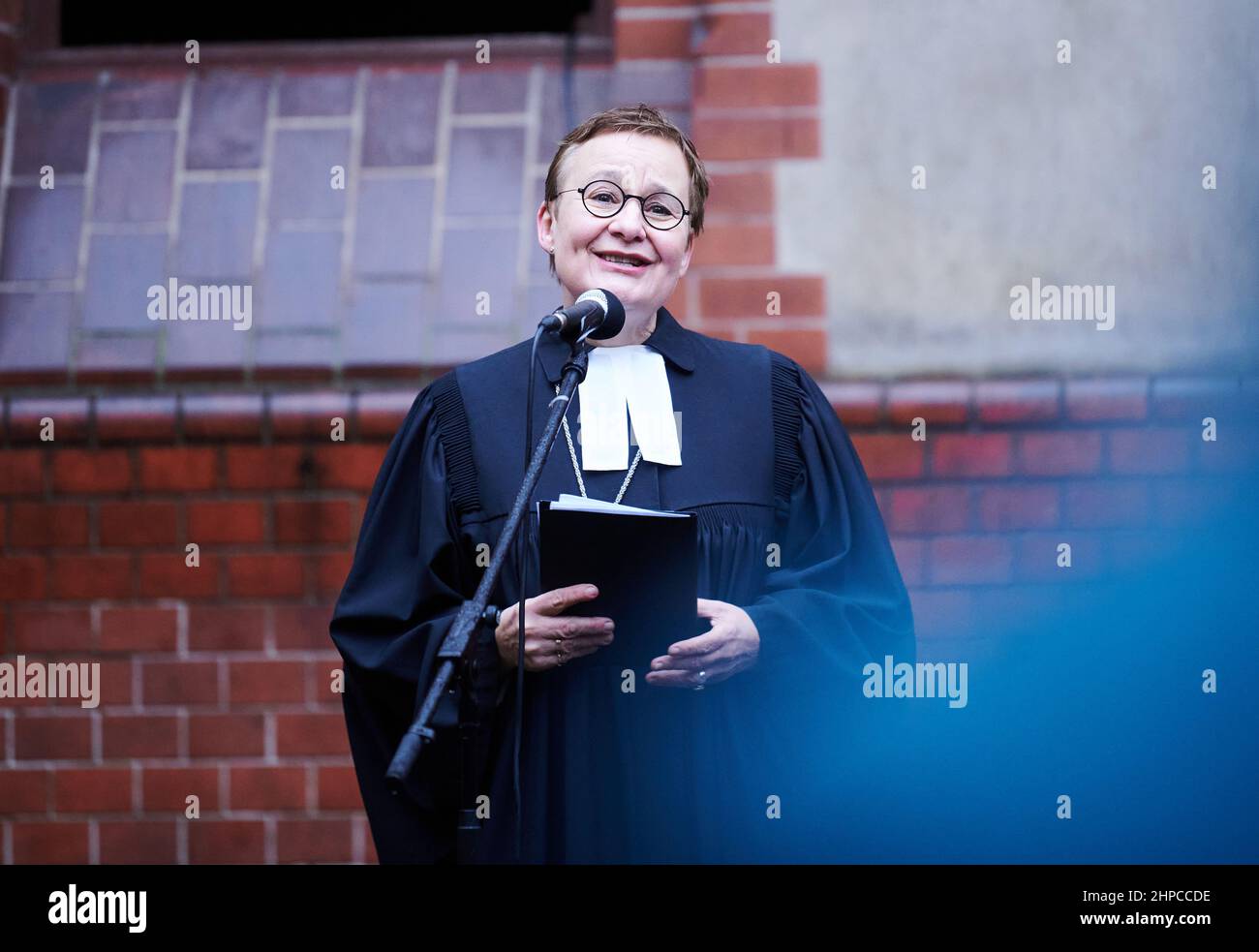 Berlin, Deutschland. 20th. Februar 2022. Ulrike Trautwein, Pfarrerin und Generalsuperintendentin des Berliner Bezirks der Evangelischen Kirche, hält einen Gedenkgottesdienst im Innenhof der Paul-Gerhardt-Kirche. Ein unbekannter Täter hatte die Kirche am 20. Januar 2022 in Brand gesetzt. Der Altar und die Orgelpfeifen wurden zerstört. Quelle: Annette Riedl/dpa/Alamy Live News Stockfoto