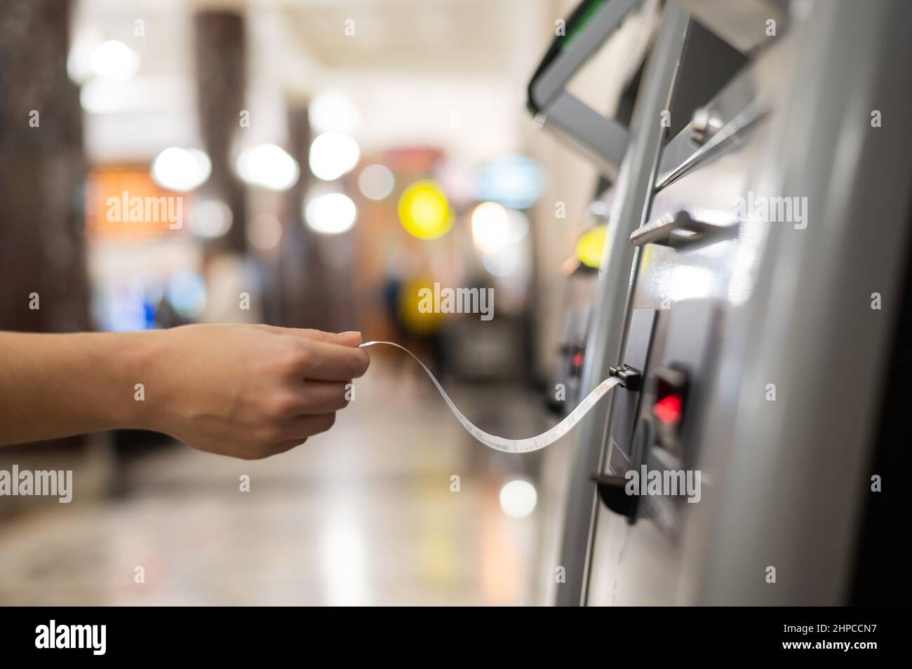 Eine Frau nimmt ein Zugticket von einem Selbstbedienungskartenschalter. Stockfoto