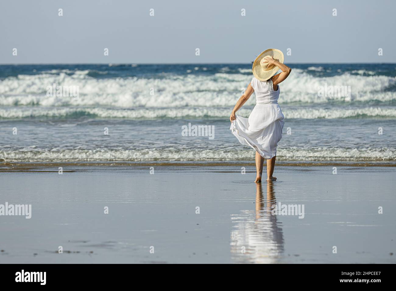 Nicht erkennbare Frau, die das winkende Meer bewundert Stockfoto